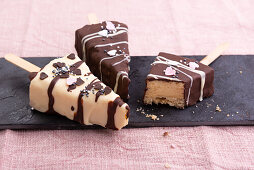 Vegane Vanille-Cheesecake-Sticks, überzogen mit heller und dunkler Kuvertüre