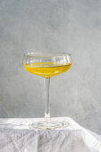 Limocello drink with lemon slice in sun light with shadows