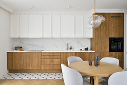 Kitchen with partly wooden front, dining area in the foreground