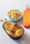 Würzige Hähnchen-Empanadas aus Südafrika serviert mit Popcorn und Getränk