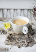 A cup of coffee on a knitted napkin on the Easter table