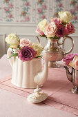 Pastel-coloured roses in teapots