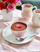 Schokoladenmousse mit Rosenblüten in Porzellantasse