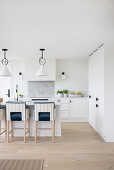 Bright kitchen, bar stools with blue and white upholstery at kitchen island