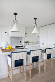 Bright kitchen, bar stools with blue and white upholstery at kitchen island