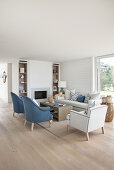 Seating area in blue and white in front of fireplace in open-plan living room