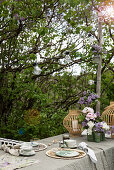 Set table under lilac bush in garden