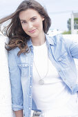 A young woman wearing a white t-shirt and a denim shirt