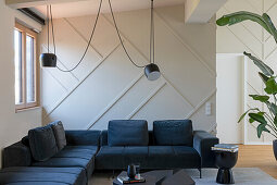 Elegant living room with dark sofa set, black coffee table, pendant light and houseplant