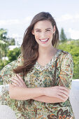 A young woman wearing a colorful, airy summer blouse