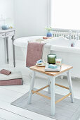 Bathroom with freestanding bathtub and wooden stool with candles