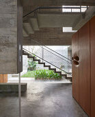 Main entrance with view of stairs and courtyard in concrete house