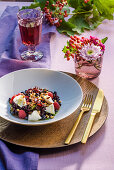 Salad with goat cheese, blueberries, raspberries, pine nuts, herbal pesto and olive oil