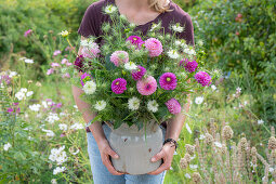 Bouquet of dahlias and maidenhair in clay pot