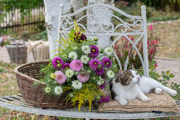 Dahlias, goldenrod and damsel in the green as cut flowers in wicker basket