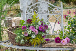 Dahlias, goldenrod and damsel in the green as cut flowers in wicker basket