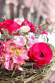 Basket with spring flowers in red and pink