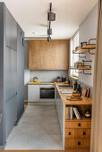 Küche in gedeckten Grautönen und Naturholz, großformatige Bodenfliesen in Betonoptik