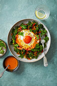 Fried eggs with turmeric on kale salad