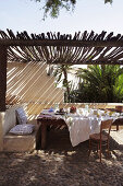 Set table on terrace with sunshade