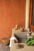 Gemauerter Waschtisch vor orangefarbener Wand