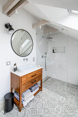 Loft bathroom with patterned tiled floor, stand up shower and vanity with countertop basin