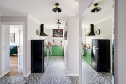 View from hallway into narrow kitchen, its reflection in the foreground