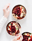 Schokoladen-Porrige-Bowl mit Kirschen, Erdbeeren, Granola und Banane