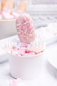 Pink cake lolly in a cup with sugar hearts