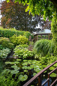 Garden with pond, water lilies and pavilion in the background