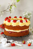 Cream cake with jam, strawberries and flowers