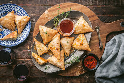 Filo pastry triangles filled with goat cheese with honey, chili sauce