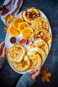 Pancakes mit Orangenscheiben, Feigen, Ahornsirup und Schokoladenstückchen