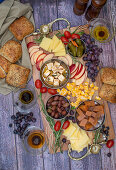 Käsebrett mit Obst, Oliven, Weintrauben und Brot