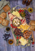 Cheese board with fruit, olives, grapes and bread