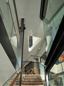 Central staircase with glass railing panels and skylight