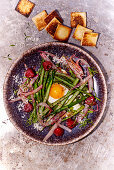 Green asparagus nest with egg and raspberries