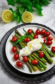 Fried green asparagus with burratini, cherry tomatoes and lemon zest