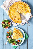 Onion and cheese pie with salad garnish