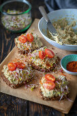 Bread with avocado bean spread, sprouts and tomatoes