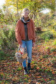 Frau mit Picknickkorb beim herbstlichen Spaziergang