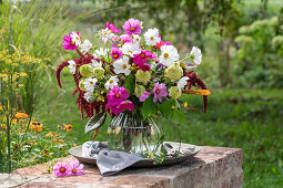 Blumenstrauß aus Sonnenhut 'Delicous Nougat' (Echinacea), Cosmea (Cosmos),  Fuchsschwanz (Amaranthus), Rosen 'Double Delight' (Rosa), Brokkoli auf Gartenmauer