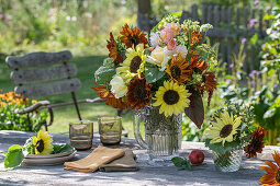 Blumenstrauß mit Sonnenblumen (Helianthus), Rosen (Rosa), Brokkoli, Wilde Möhre, Fuchsschwanz (Amaranthus) auf Gartentisch