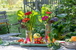 Bauernbrotzeit, Tischdeko mit Blumenstrauß aus Zinnen (Zinnia) und Mangoldblättern, Brotzeitbrett mit Tomaten, Paprika