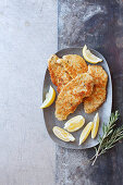 Schweineschnitzel mit Panade aus Zitrone, Pinienkernen und Parmesan Schweineschnitzel