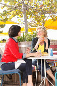 Two girlfriends eating outside