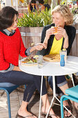 Two girlfriends eating outside