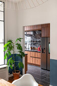 View from dining room of customized kitchen with wooden cabinets and marble surfaces