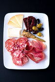 Tapas mit Artischocke, Parmaschinken, Salami, Käse, getrockneten Tomaten und Oliven