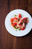 Antipasti with Italian ham, tomatoes, and spring onions